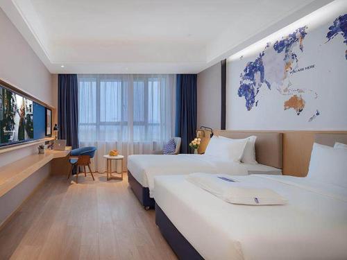 a hotel room with two beds and a map of the world at Kyriad Marvelous Hotel Jingxian in Jing