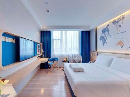 a hotel room with a large bed and a tv at Kyriad Marvelous Hotel Chengdu Wuhou Shuangnan in Chengdu