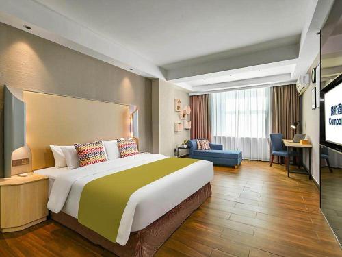 Pokój hotelowy z dużym łóżkiem i telewizorem w obiekcie Campanile ShenZhen Longhua Dalang Business Centre w mieście Longhua