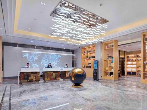 Kyriad Marvelous Hotel Guangzhou Baiyun International Airport في قوانغتشو: متحف مع كرة كبيرة في وسط الغرفة