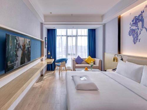 PingxiangにあるKyriad Hotel Pingxiang Wanlong Bay Branchの大きなベッドとリビングルームが備わるホテルルームです。