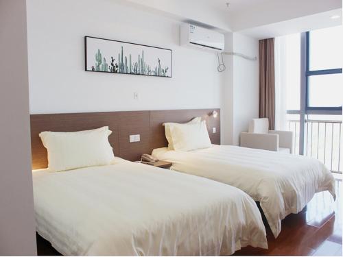 a hotel room with two beds and a window at JinJiang Inn Fashion Zhenjiang Dagang Pingchang Road in Zhenjiang