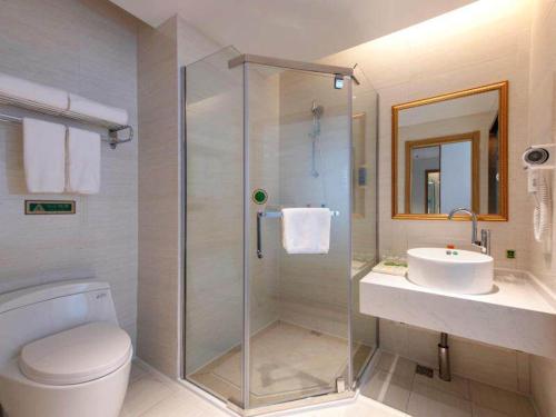 a bathroom with a shower and a toilet and a sink at Vienna SanHao Hotel Danyang Houxiang in Matunlijia