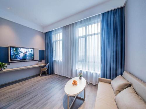 a living room with a couch and a table at Kyriad Marvelous Hotel Qinhuangdao Nandaihe in Qinhuangdao