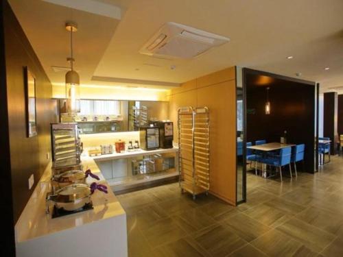eine große Küche und ein Esszimmer mit einem Esstisch in der Unterkunft Jinjiang Inn Yangzhou Gaoyou East Haichao Road in Gaoyou