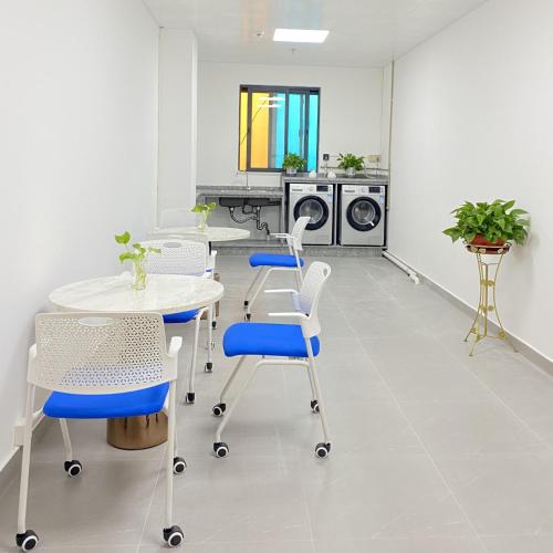 a room with a table and chairs and a kitchen at Kyriad Marvelous Hotel Zhongshan West District in Changzhou