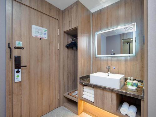 a bathroom with a sink and a mirror at Campanile Yangzhou China Grand Canal & Ho Family Garden in Yangzhou