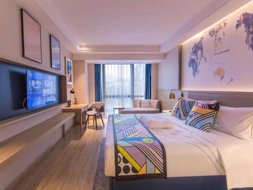 a hotel room with a bed and a flat screen tv at Kyriad Marvelous Hotel Shenzhen Linheng Plaza Liuyue Subway Station in Liantang