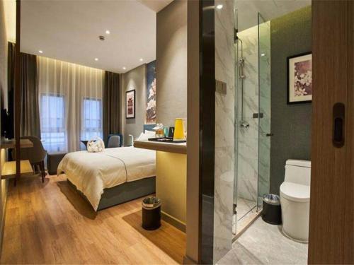 a bedroom with a bed and a bathroom with a shower at Magnotel Nanjing University of Aeronautics and Astronautics Shengtai West Road in Jiangning