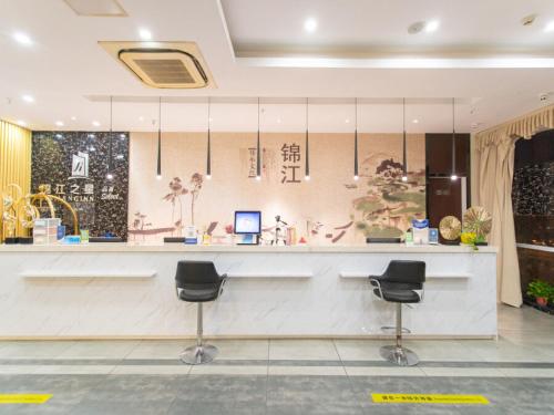 un vestíbulo con un mostrador con dos taburetes en Jinjiang Inn Yangzhou Slender West Lake Dongguan Street en Yangzhou
