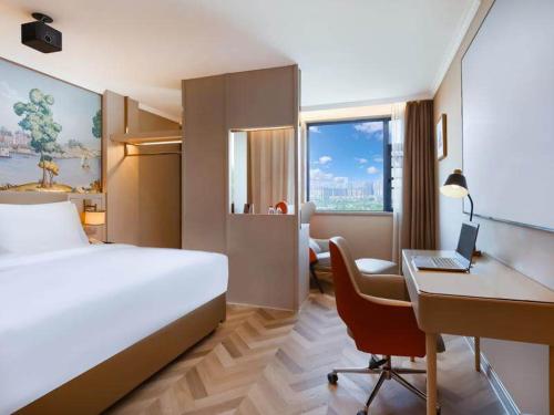 a hotel room with a bed and a desk with a laptop at Vienna Hotel Changsha Yuelu Mountain University city Xihu Park in Changsha