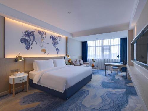 a hotel room with a bed and a map of the world at Kyriad Marvelous Hotel Hengyang Changning in Changning