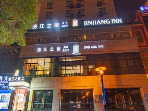 un edificio con un cartel encima por la noche en Jinjiang Inn Yangzhou Slender West Lake Dongguan Street en Yangzhou