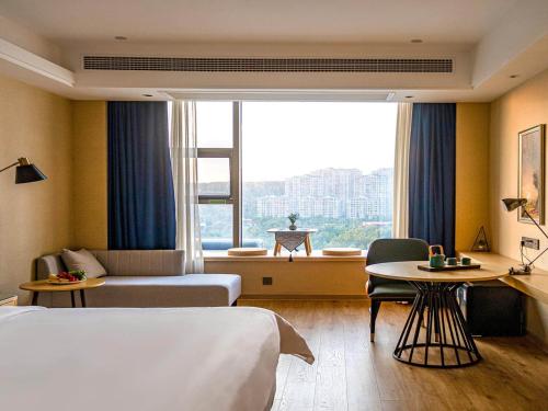 a hotel room with two beds and a window at Vienna International Hotel Jiangsu Wuxi Jiangyin Sports Center in Jiangyin