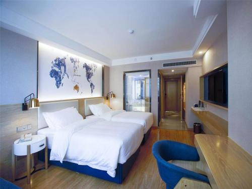 a hotel room with two beds and a tv at Kyriad Marvelous Hotel Changsha Xiangya in Changsha