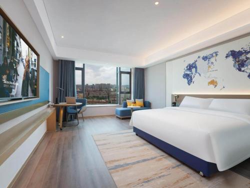 Habitación de hotel con cama y mapa en la pared en Kyriad Jinjiang Hotel en Jinjiang