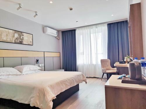 a hotel room with a large bed and a desk at JinJiang Inn Zhenjiang Yangzhong Yangzi Road shop in Yangzhong