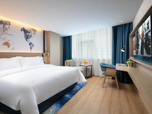 Habitación de hotel con cama grande y escritorio. en Kyriad Marvelous Hotel Changde Pedestrian Street, en Changde