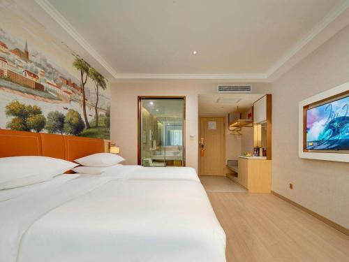 a bedroom with a large white bed and a bathroom at Vienna Hote Nanjing Lishui Tianshengqiao Avenue Wuxiang Shuizhen 5 0 in Lishui