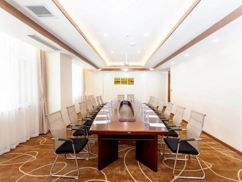 a conference room with a long table and chairs at Kyriad Marvelous Hotel Weihai Railway Station in Weihai