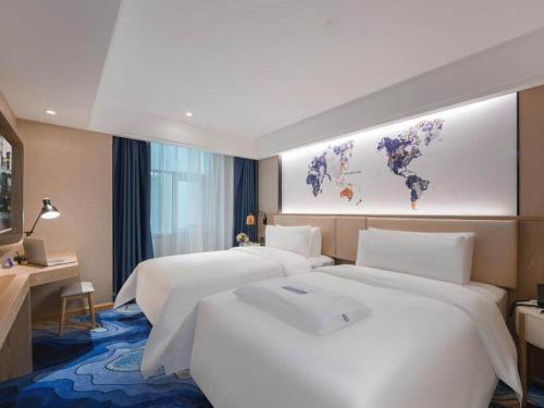 a hotel room with two beds and a map of the world at Kyriad Marvelous Hotel Shenzhen Guangming Zhenmei Subway Station in Bao'an