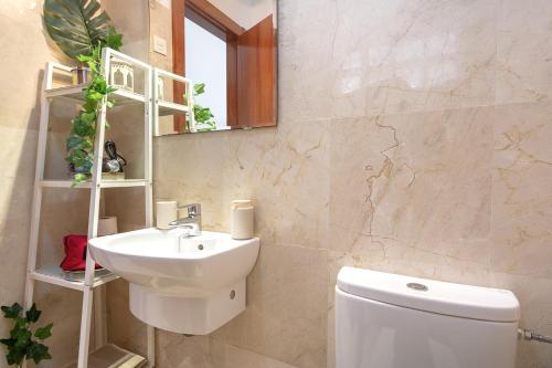 uma casa de banho com um lavatório, um WC e um espelho. em -MalagaSunApts-Pop Dream CityCentre em Málaga