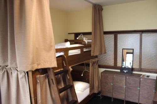 a bedroom with two bunk beds and a dresser at Guesthouse KYOTO COMPASS in Kyoto