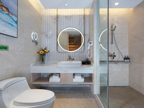 a bathroom with a toilet and a sink and a mirror at Vienna International Hotel Chongqing North Station in Chongqing