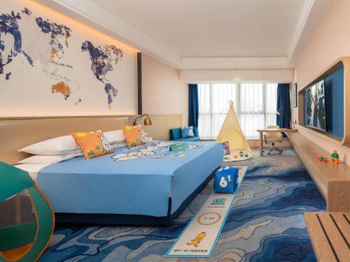 a hotel room with a blue bed and a world map on the wall at Kyriad Marvelous Hotel Shenzhen Longhua District Qinghu Subway Station in Tiantangwei