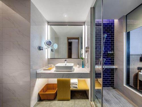 a bathroom with a sink and a shower at Kyriad Marvelous Hotel Chaozhou Fortune Central in Chaozhou