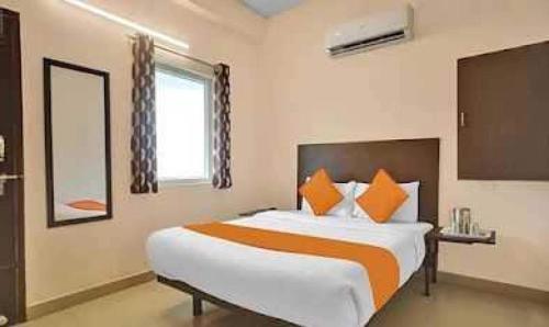 a bedroom with a large bed with orange and white pillows at OYO Flagship ELEGANT RESIDENCY in Chennai