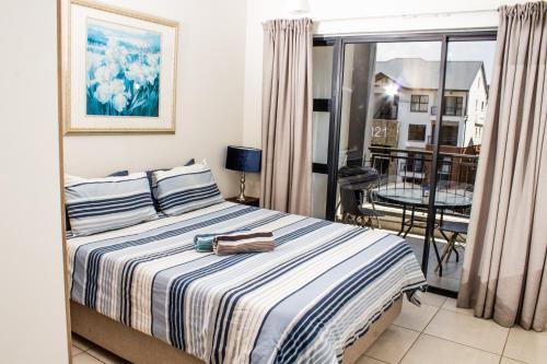 a bedroom with a bed and a balcony at 1368 The Blyde Crystal Clear 1 Bedroom Apartment in Pretoria