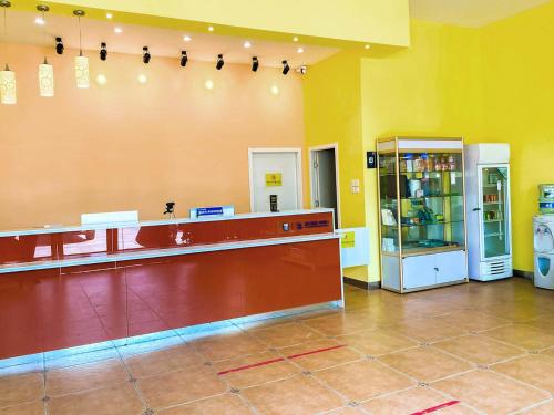 a large room with a counter and a refrigerator at 7Days Inn Danyang Train Station Wuyue Square Branch in Zhenjiang
