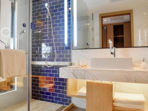 a bathroom with a sink and a mirror at Kyriad Marvelous Hotel Hengyang Changning in Changning