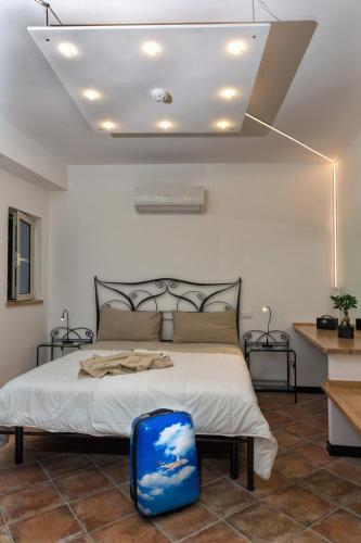 a bedroom with a bed with a blue suitcase on the floor at Giasone Apartments in Taormina