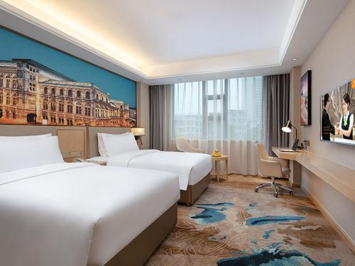 Cette chambre comprend deux lits et un bureau. dans l'établissement Vienna hotel Hunan Shaoyang Longhui Bus Station, à Longhui