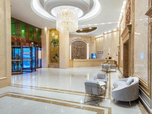 un grand hall avec un lustre et des chaises dans un bâtiment dans l'établissement Vienna International Hotel Taizhou Wenling Branch, à Taizhou