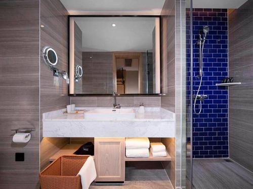 La salle de bains est pourvue d'un grand lavabo et d'une douche. dans l'établissement Kyriad Marvelous Hotel Foshan New City Lecong Town, à Shunde