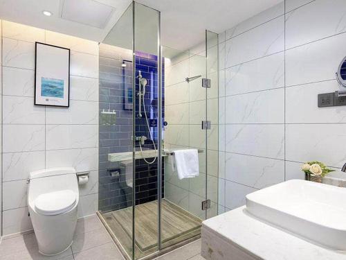 a bathroom with a shower and a toilet and a sink at Kyriad Marvelous Hotel Changde Pedestrian Street in Changde