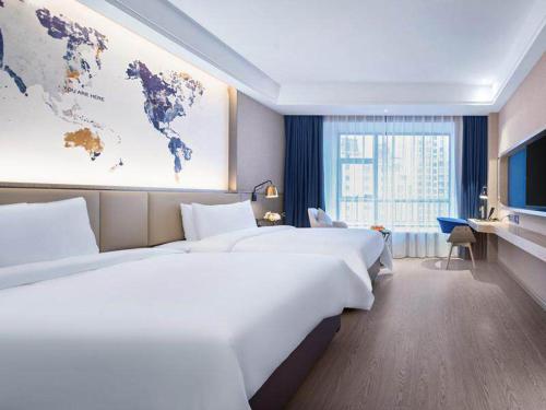 a hotel room with two beds and a map of the world at Kyriad Marvelous Hotel Guizhou Dujun Center Wanda Plaza in Duyun