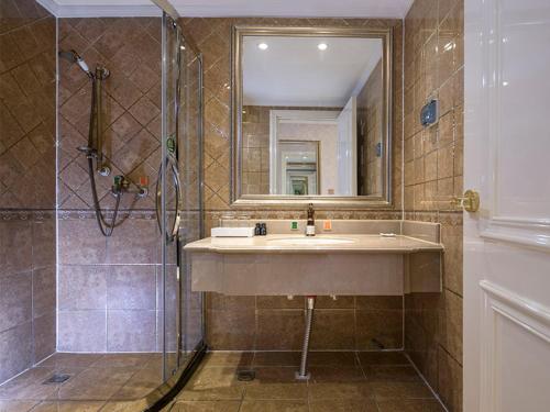 La salle de bains est pourvue d'un lavabo et d'une douche. dans l'établissement Vienna Classic Hotel Manzhouli Zhongsu Street, à Manzhouli