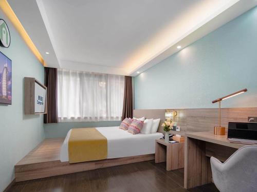 1 dormitorio con 1 cama y escritorio con ordenador en Campanile Yangzhou China Grand Canal & Ho Family Garden, en Yangzhou