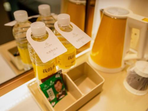 a counter with bottles of honey and a container ofbeer at Magnotel Hotel Yangzhou Jinghua Wangyue Road in Yangzhou