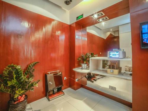a room with red walls and a tv on a shelf at Jinjiang Inn Select Yangzhou Slender West Lake Siwangting Road in Yangzhou
