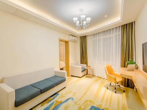 a bedroom with a bed and a desk and a deskablish at Vienna Classic Hotel Mudanjiang Railway Station in Mudanjiang