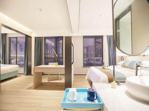 um quarto com uma casa de banho com um lavatório e um espelho em Kyriad Marvelous Hotel Changsha Hunan Financial Center em Changsha