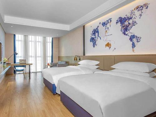 BoluoにあるKyriad Marvelous Hotel Huizhou Boluo Yuanzhouのベッド2台と壁の地図が備わるホテルルームです。