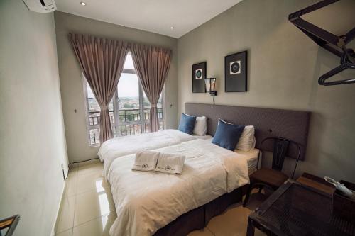 a bedroom with a large bed with two towels on it at The Majestic-Loft De Tel in Ipoh
