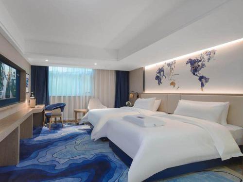 a large hotel room with a large bed and a desk at Kyriad Marvelous Hotel Shenzhen Guangming Zhenmei Subway Station in Bao'an