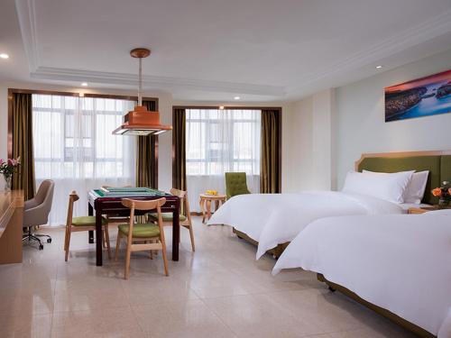 um quarto com 2 camas, uma mesa e cadeiras em Vienna SanHao Hotels Yichun Gao'an Avenue em Gao'an